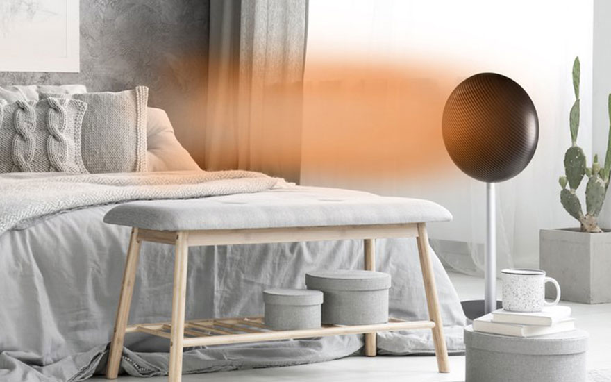 Chambre avec lit gris, banc en bois, lampadaire rond noir, cactus en pot et boîtes décoratives.