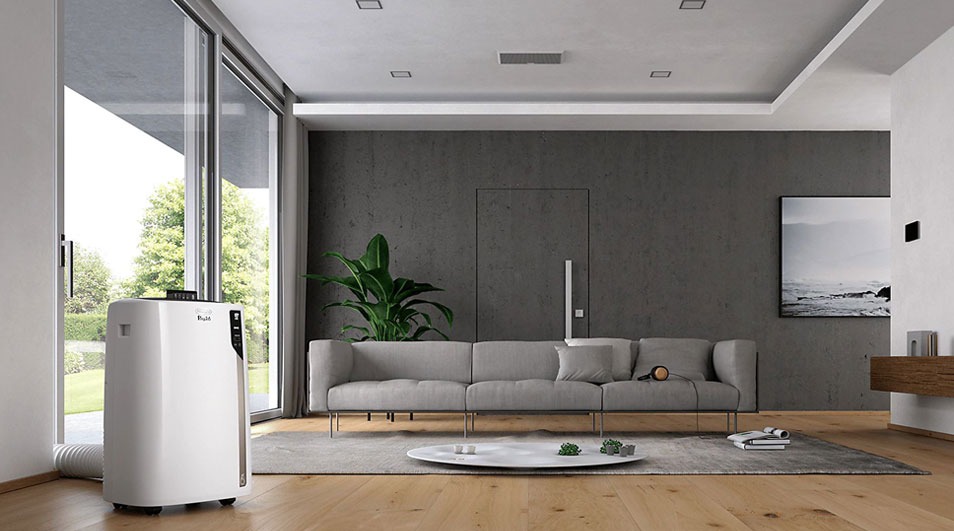 A living room features a white air conditioner, grey sofa, round table, and wood floor. A large window shows trees outside.