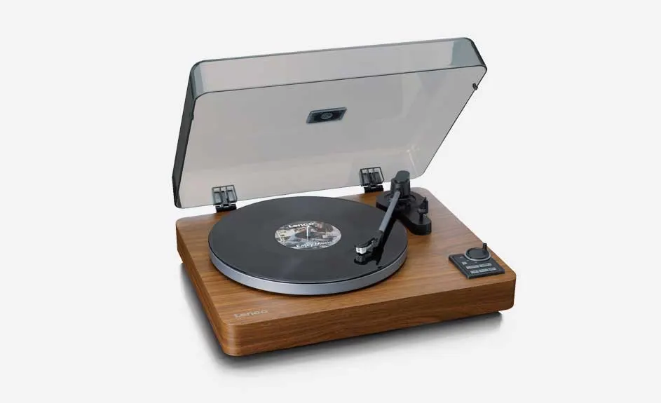 Platine vinyle marron avec couvercle transparent ouvert, disque noir, bras de lecture noir et boutons de commande sur fond blanc.