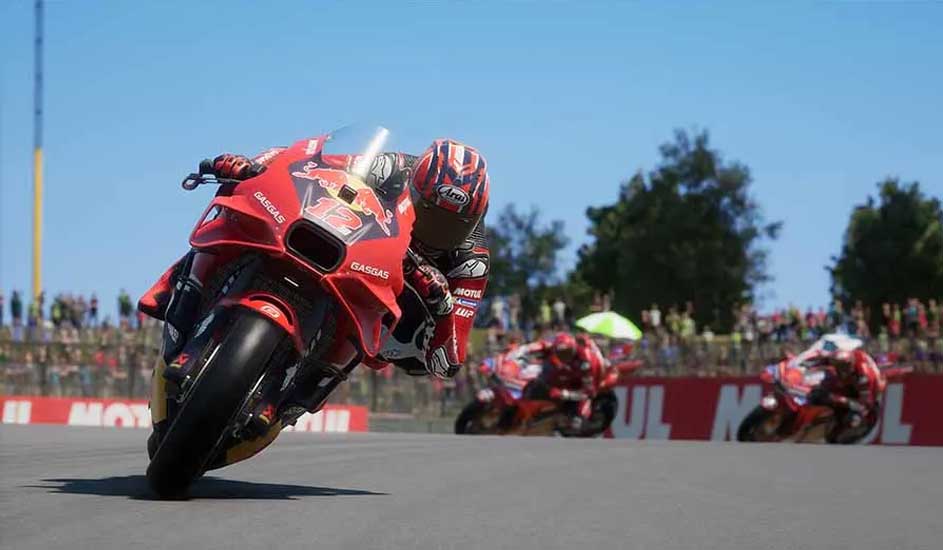 Rode GasGas motorfietsen racen op een circuit onder een heldere blauwe hemel. Publiek en bomen op de achtergrond.