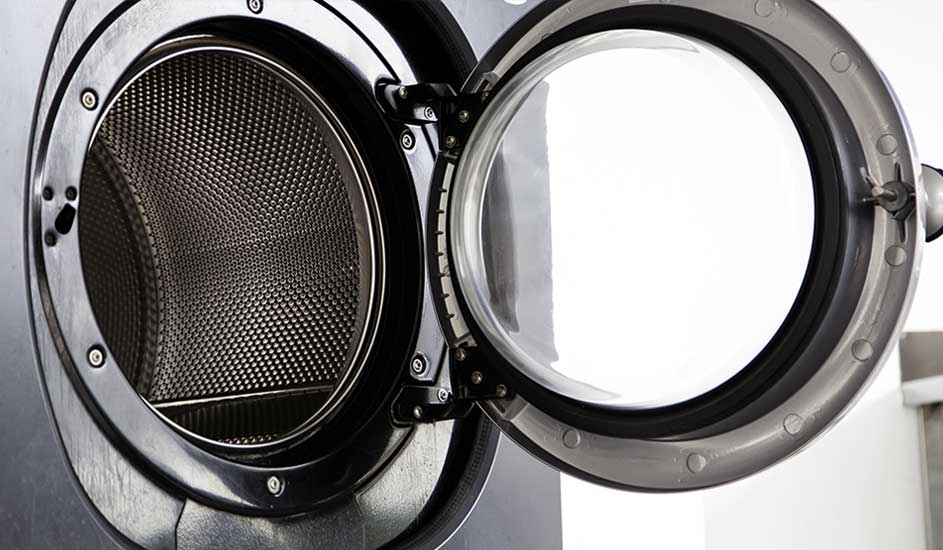 The door of a washing machine is open, showing the empty drum in detail. No brand is visible on the appliance.