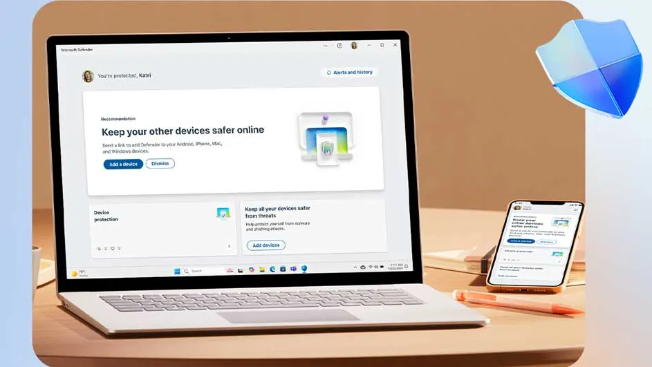 Un ordinateur portable et un smartphone affichent le logiciel de sécurité Microsoft Defender sur un bureau avec un stylo.