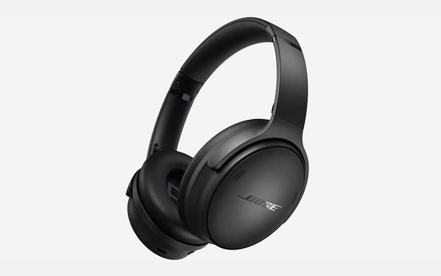 Een zwarte gitaartas en een zwarte leren jas op een metrostation, met een zilveren trein op de achtergrond.