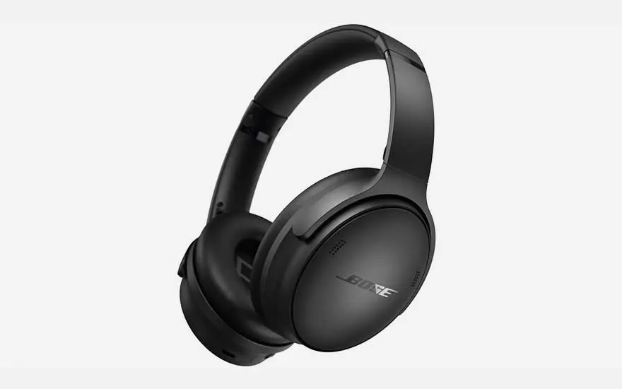 Een zwarte gitaartas en een zwarte leren jas op een metrostation, met een zilveren trein op de achtergrond.