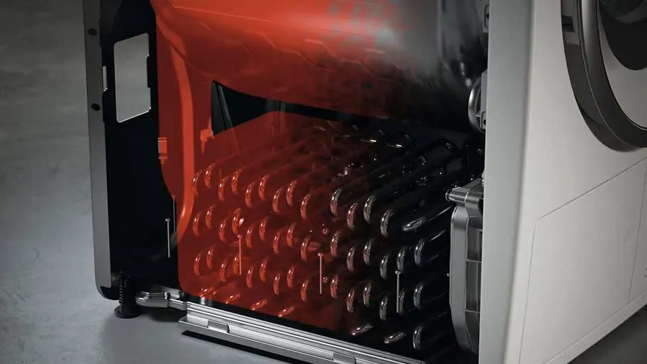 Detailfoto van een wasmachine met open achterkant, toont rode en zwarte spoelen. Witte buitenkant zichtbaar.