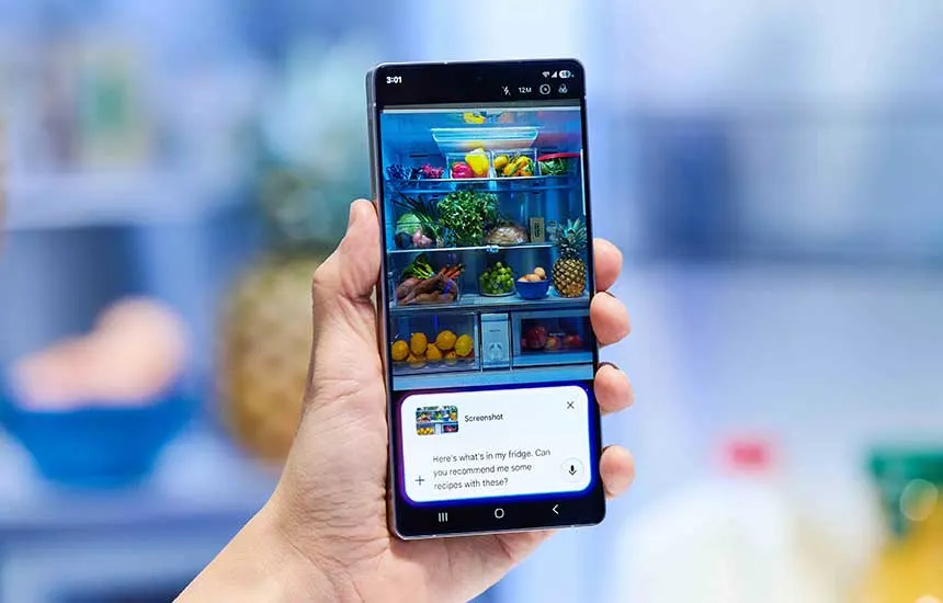 Een hand houdt een smartphone met een foto van een gevulde koelkast; onderaan staat een AI-tekstvak dat om recepten met deze ingrediënten vraagt.