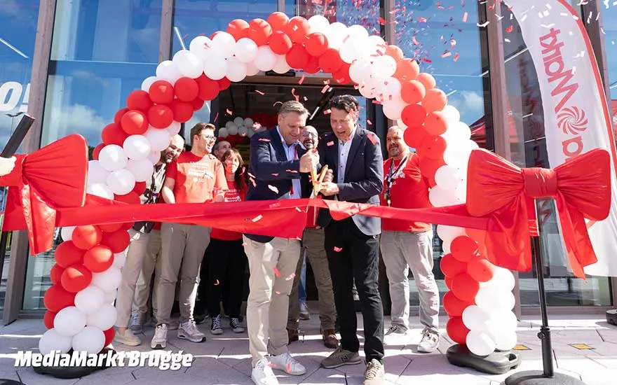 Festive opening of MediaMarkt Bruges, with red and white balloons, ribbon, large scissors and a smiling team.