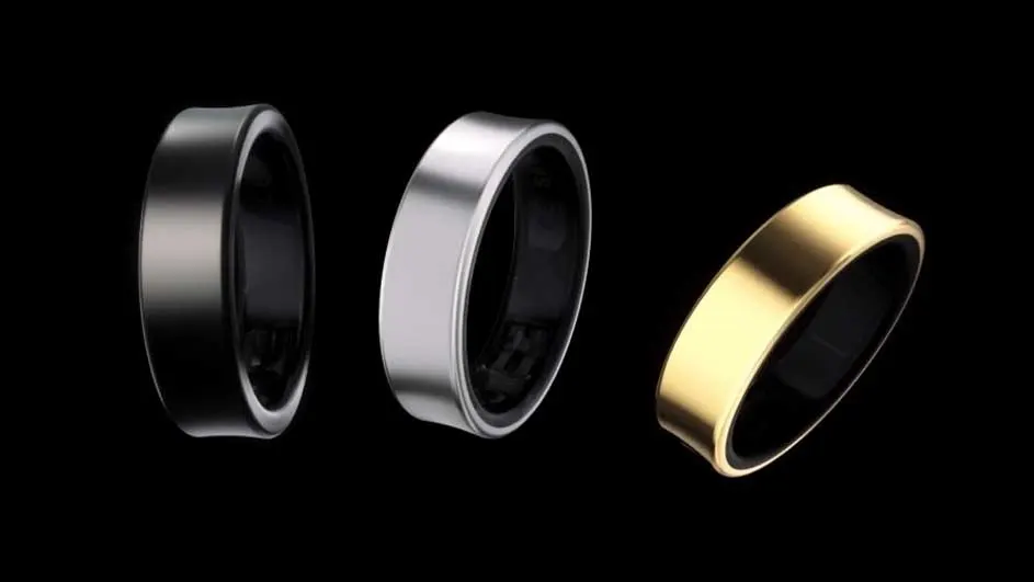 Drie ringen: zwart, zilver en goud, liggen op een zwarte achtergrond. De binnenkant van elke ring is zwart.