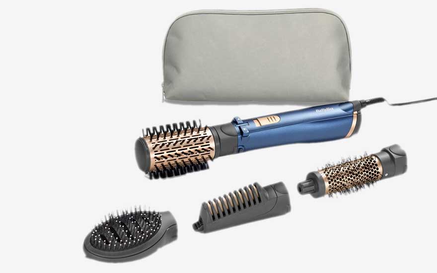 Une brosse soufflante bleue avec plusieurs accessoires et une trousse de rangement est présentée sur fond blanc.
