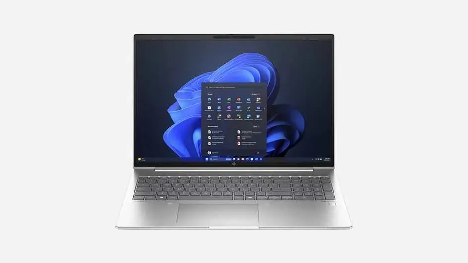 Silver laptop displaying Windows 11 home screen with dark blue background featuring characteristic blue spiral shape and visible widgets.