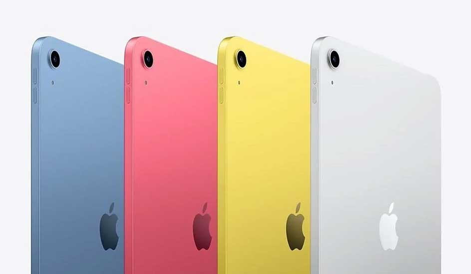 Four iPads are displayed in a row against a white backdrop, each in a different color: blue, pink, yellow, and white. The Apple logo is visible on each device.