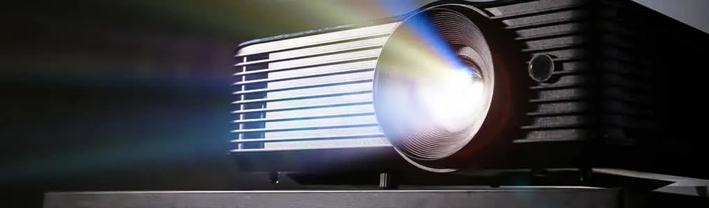 Un projecteur noir projette une lumière vive sur un fond sombre. Les évents sont visibles sur le côté.