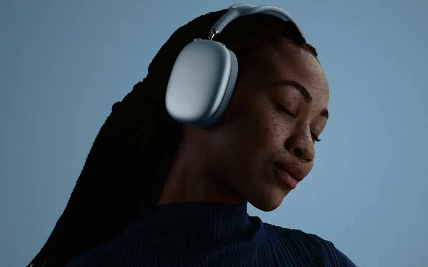 A person with long braided hair wears light blue headphones, eyes peacefully closed while soft blue-toned lighting bathes the background.