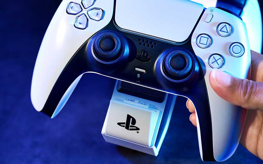Manette de jeu blanche et noire sur station de charge blanche avec logo noir sur fond bleu.
