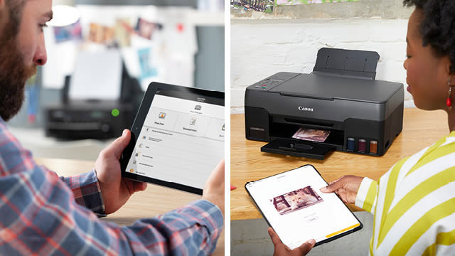 Twee personen gebruiken elk een tablet om een zwarte Canon printer te bedienen op een houten bureau.