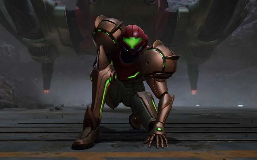 Samus agenouillée dans son armure brune avec des accents verts dans un environnement industriel sombre avec des piliers imposants.