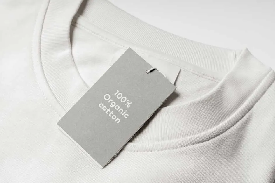 Gros plan d'un t-shirt blanc avec une étiquette grise indiquant "100% coton biologique".