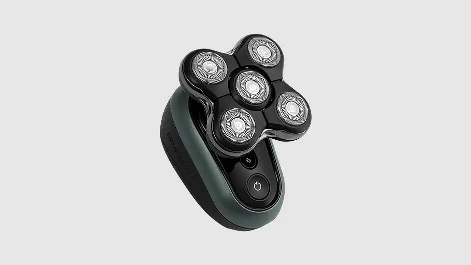 Un rasoir électrique noir et gris avec cinq têtes rotatives est sur un fond gris uni.