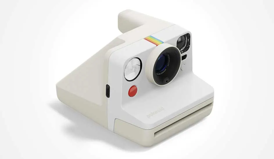 Witte Polaroid-camera met regenbooglijn, grote lens, ronde flitser en rode knop. Retro design met moderne accenten.