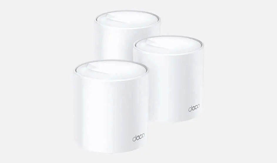 Drie witte, cilindervormige Deco-routers staan op een witte achtergrond. Het Deco-logo staat op twee ervan.