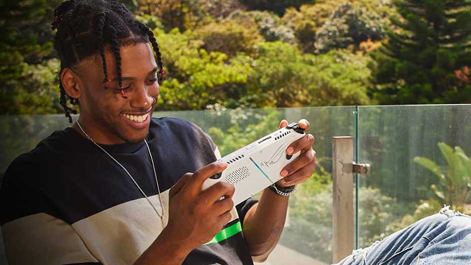 Un écran de jeu blanc est tenu à l'extérieur, avec une végétation verte et un ciel en arrière-plan.