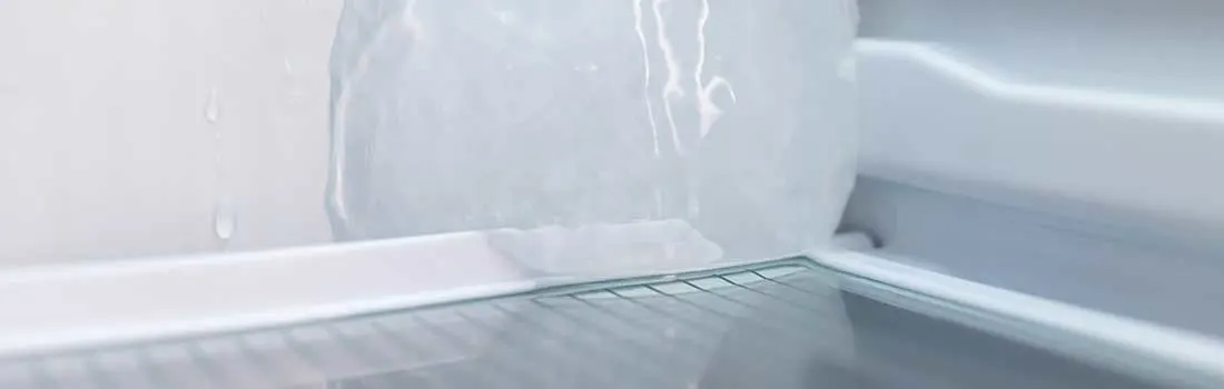 Intérieur de réfrigérateur blanc vide avec étagères métalliques et gouttes d'eau sur les parois.