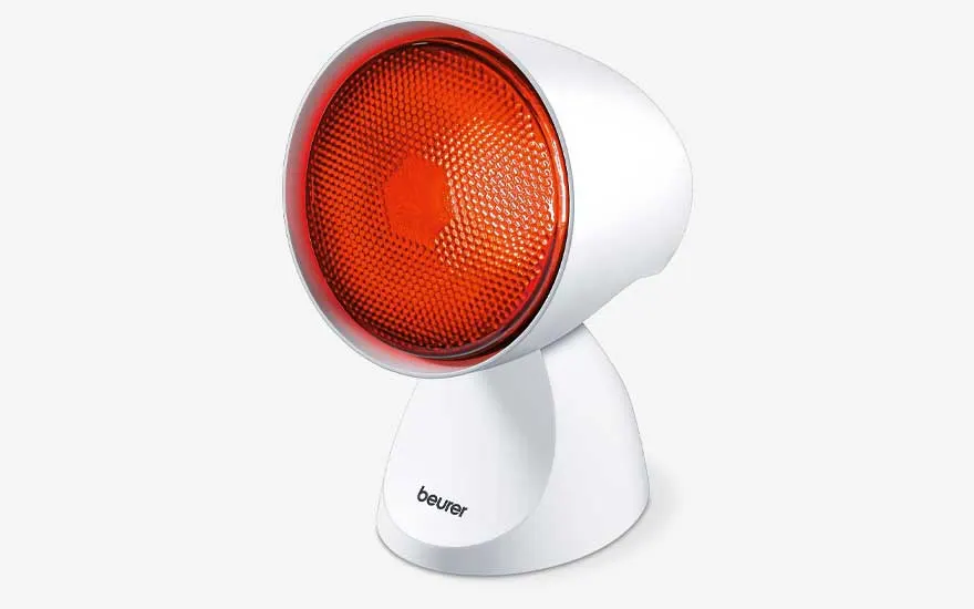 Une lampe chauffante compacte, avec réflecteur rouge et base blanche, est inclinée sur un fond blanc net.