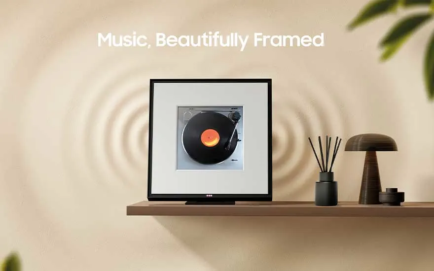 A modern room with a shelf displaying a frame featuring a record player. Decorative objects sit nearby with soft lighting accents.