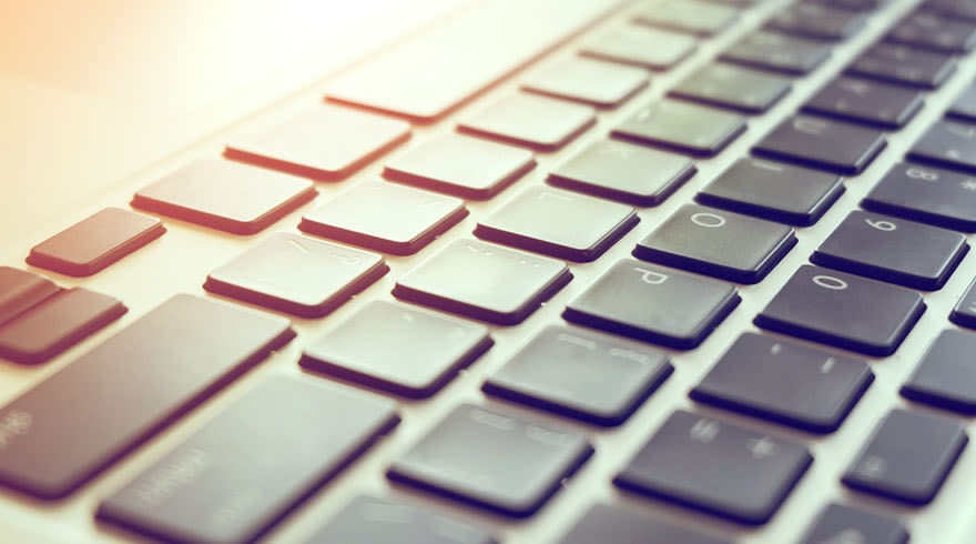 Gros plan sur un clavier d'ordinateur avec des touches noires et blanches. L'éclairage est lumineux.