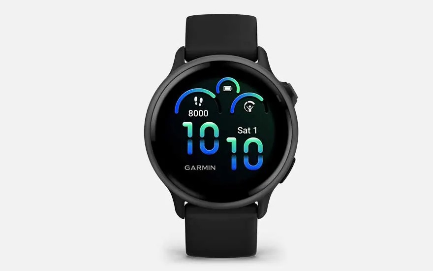 Une montre Garmin noire affiche l’heure, la date, les pas, la batterie et des notifications sur un écran rond et coloré.