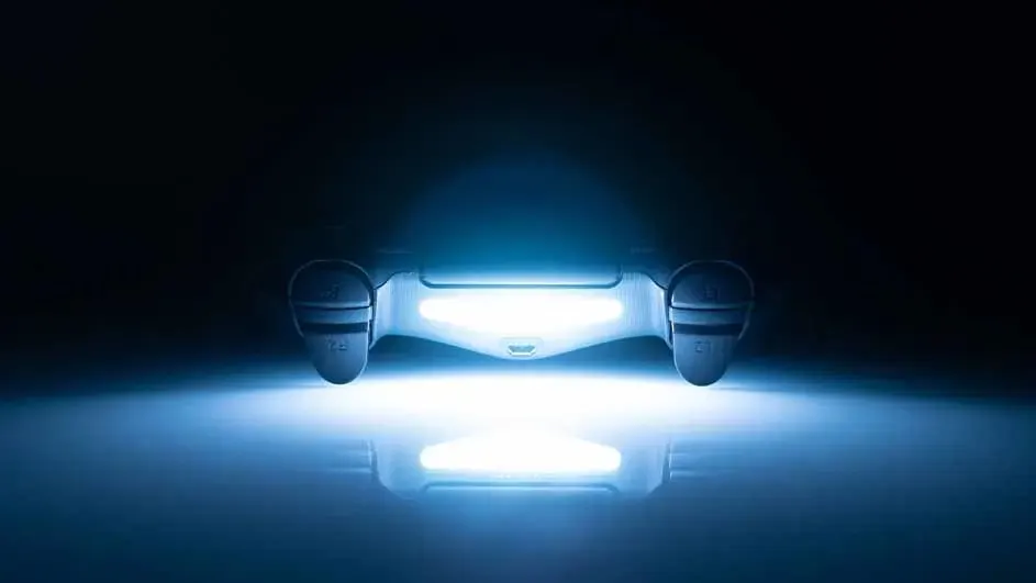 Manette de jeu avec lumière bleue sur fond noir. La lumière se reflète sur une surface en dessous.