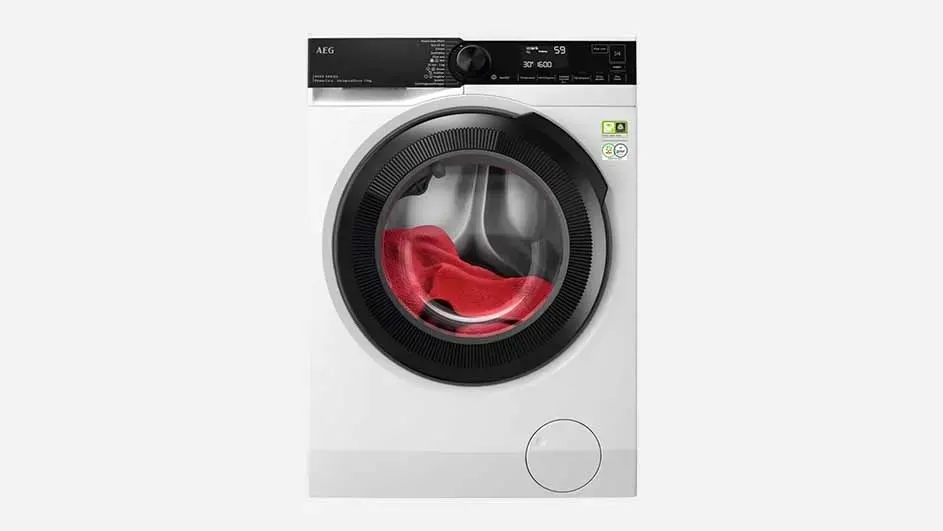 Een witte AEG wasmachine wast een rode handdoek, met een digitaal scherm en modern design in een minimalistische ruimte.