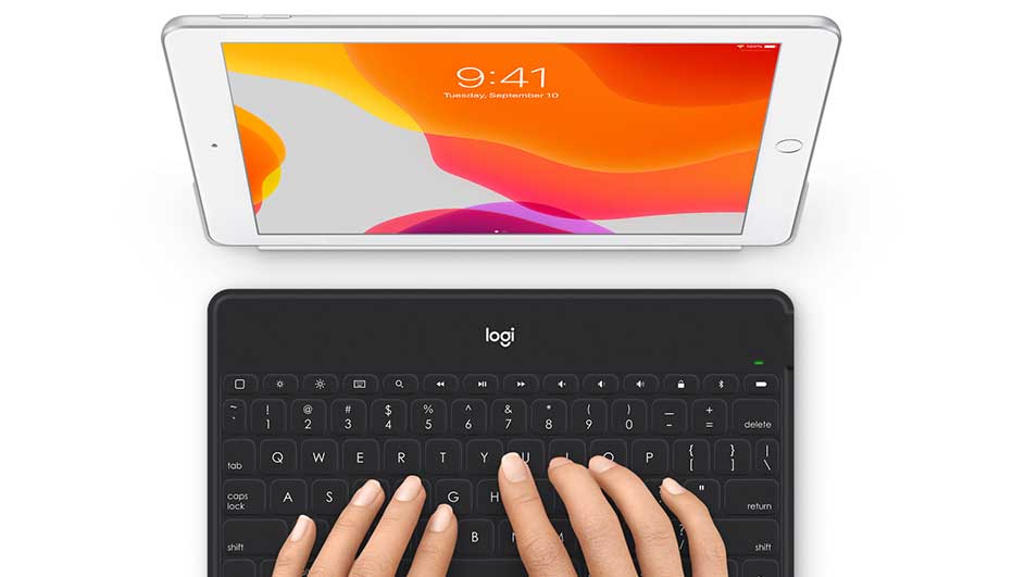 Vue rapprochée d'une tablette blanche au-dessus d'un clavier noir Logitech. L'écran de la tablette affiche 9:41 avec un fond d'écran coloré.
