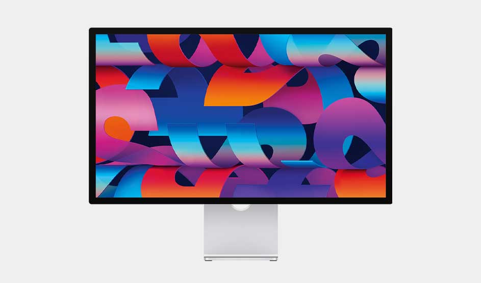 A computer monitor on a silver stand displays folded ribbons of blue, purple, pink and orange, forming a bold layered abstract design.