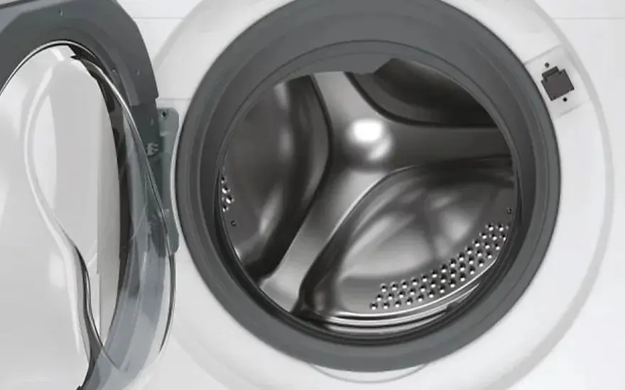 La porte ouverte d’un lave-linge vide révèle le tambour à l’intérieur, la marque n’est pas visible sur l’appareil.