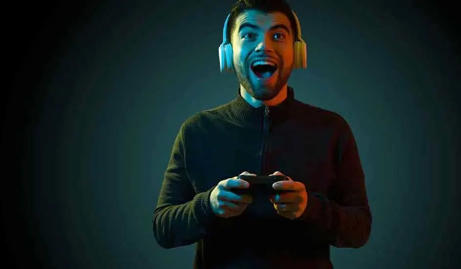 Een persoon met een koptelefoon houdt een zwarte controller vast tegen een donkerblauwe achtergrond.