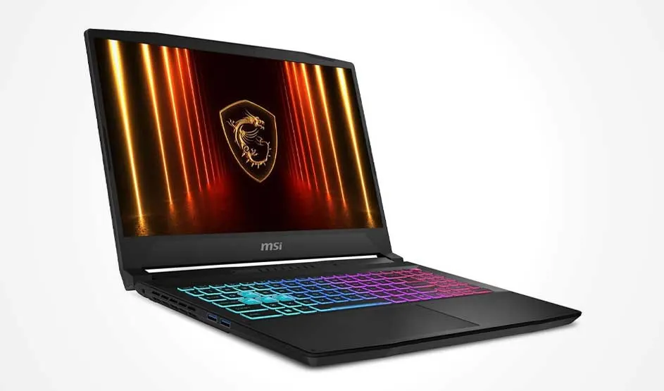A black MSI gaming laptop is angled on a white background; a rainbow RGB keyboard and a dragon crest with orange light beams fill the screen.