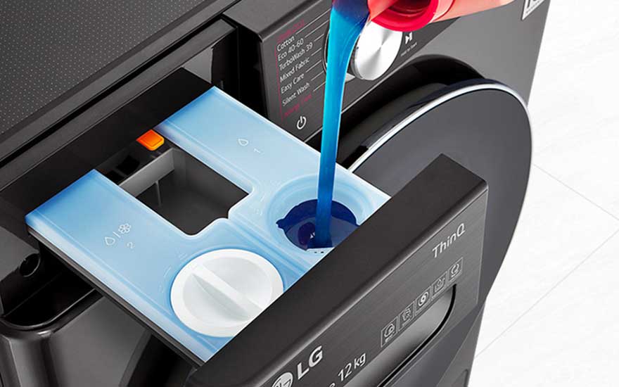 Du détergent liquide bleu est versé dans le tiroir d’une machine LG noire, prête pour un cycle de lavage.
