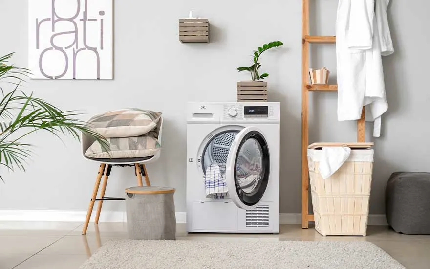 Buanderie scandinave avec machine à laver blanche, échelle en bois et paniers. Décoration minimaliste avec matériaux naturels.