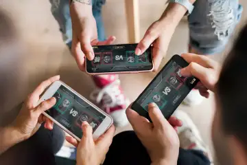 Tres personas con el móvil en las manos jugando juntos