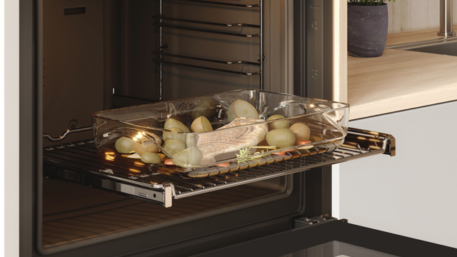 Momento de la extracción de un asado en su punto gracias a la función hornear.