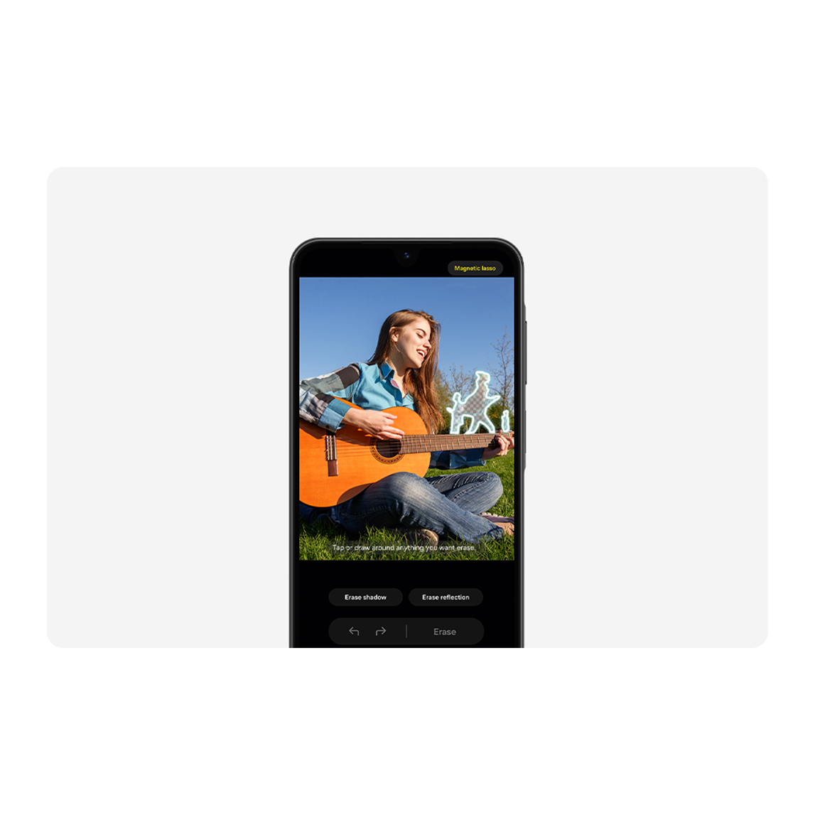 En un teléfono, una mujer toca la guitarra en un campo con un dibujo de figuras danzantes. Hay opciones para borrar sombras y reflejos.