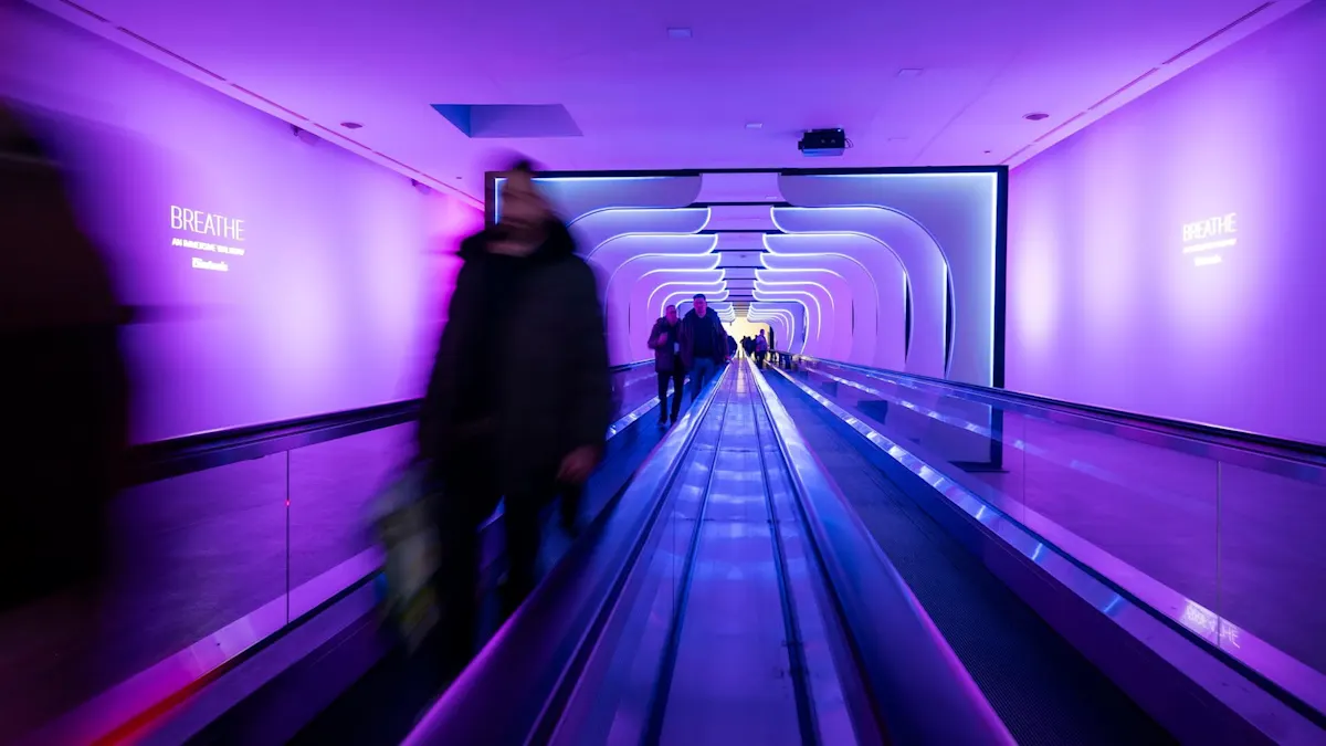 Pasillo futurista con luces LED moradas y personas en movimiento.