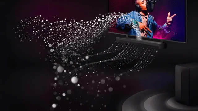 Un televisor muestra a un hombre con auriculares cantando en un micrófono. Debajo, una barra de sonido negra con luces danzantes.