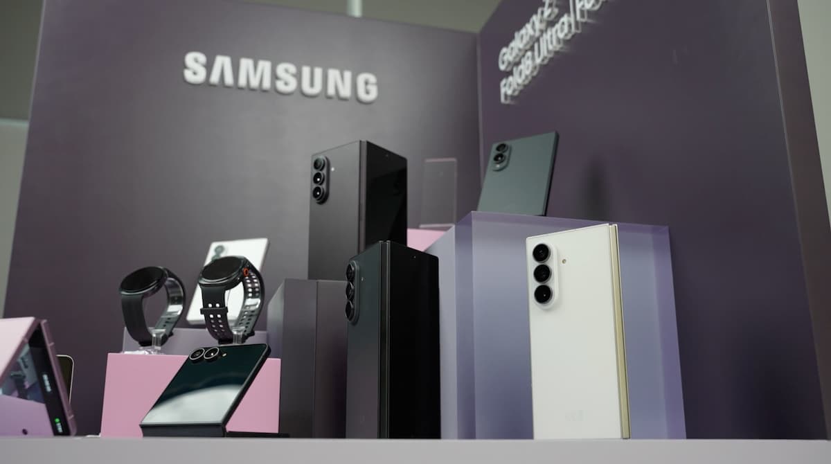 Expositor de Samsung con smartphones plegables, relojes inteligentes y teléfonos Galaxy sobre pedestales morados.