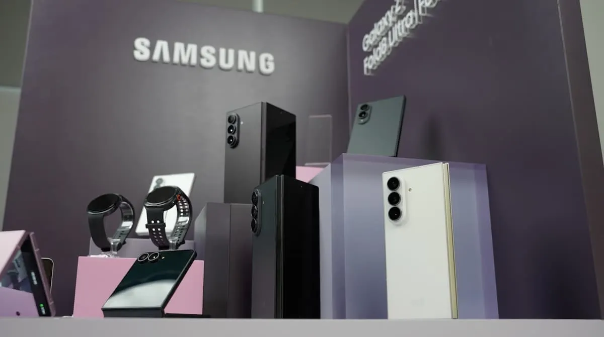 Expositor de Samsung con smartphones plegables, relojes inteligentes y teléfonos Galaxy sobre pedestales morados.