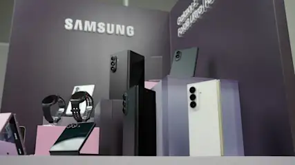 Expositor de Samsung con smartphones plegables, relojes inteligentes y teléfonos Galaxy sobre pedestales morados.