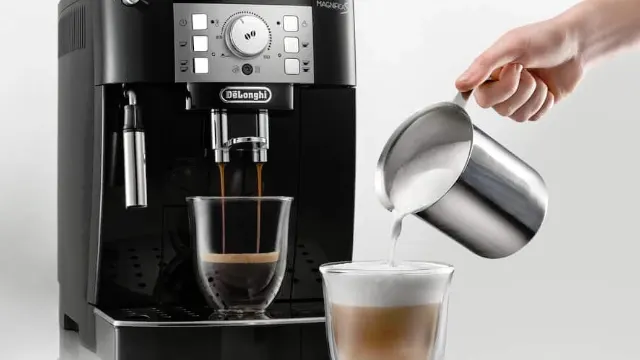 Cafetera Magnifica S de vista sirviendo un café largo, al lado una mano sirviendo el último chorro de leche a un café latte.