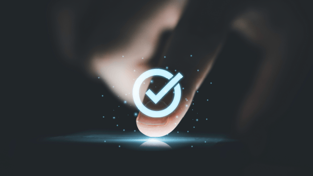 Un dedo presiona un círculo azul brillante con una marca de verificación sobre un fondo oscuro con motas y una línea azul.