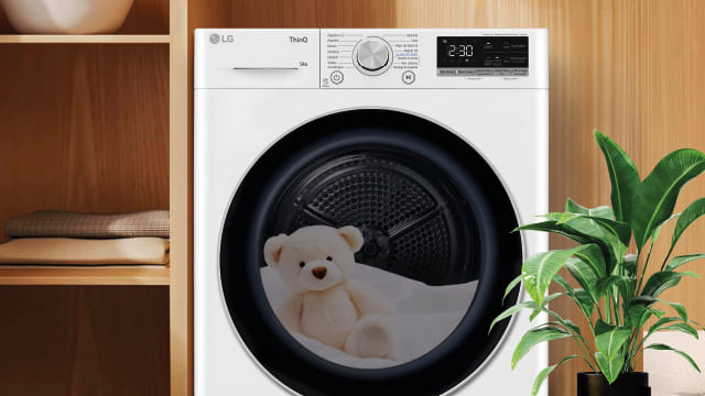 Secadora blanca con osito de peluche dentro del tambor.